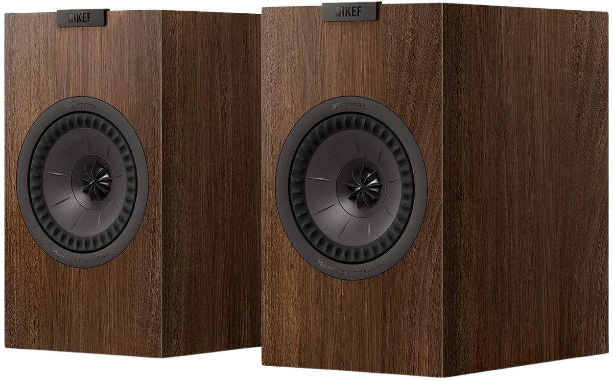 KEF Q3 Meta passive bookshelf speakers shown in a home audio setup with black cabinets and silver accents.